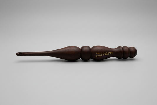Brown wooden yarn swift on a white surface