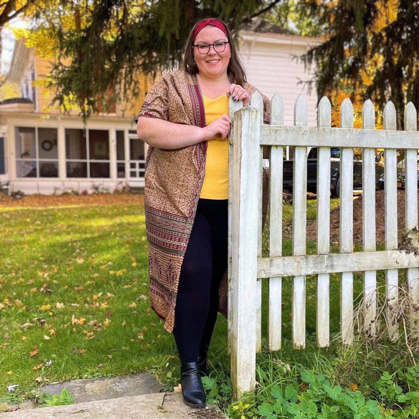 Model standing in leaves wearing an Amara Long Duster in Goddess Sizing.
