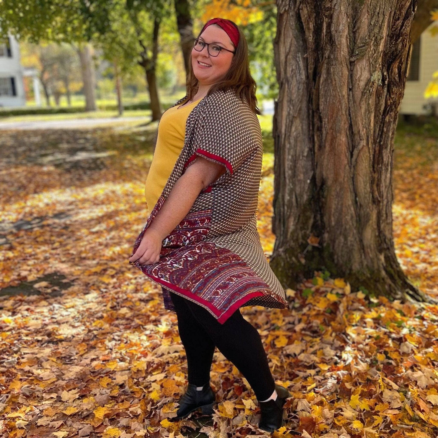 Model standing in leaves wearing an Amara Long Duster warmer tones
