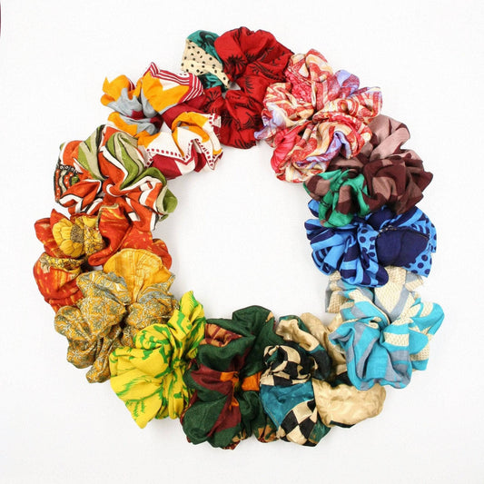 a color-wheel of assorted sari silk scrunchies on a white backdrop.