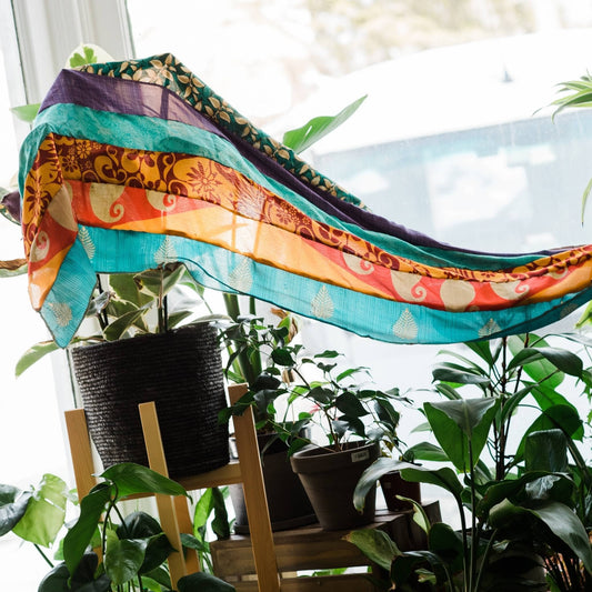 Medley scarf sitting on a window with some plants.