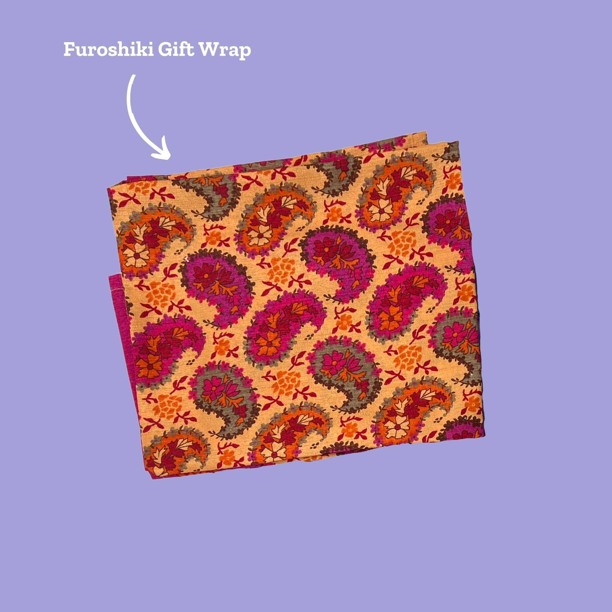 Orange and pink paisley print on a furoshiki. Arrow points and reads Furoshiki Gift Wrap.