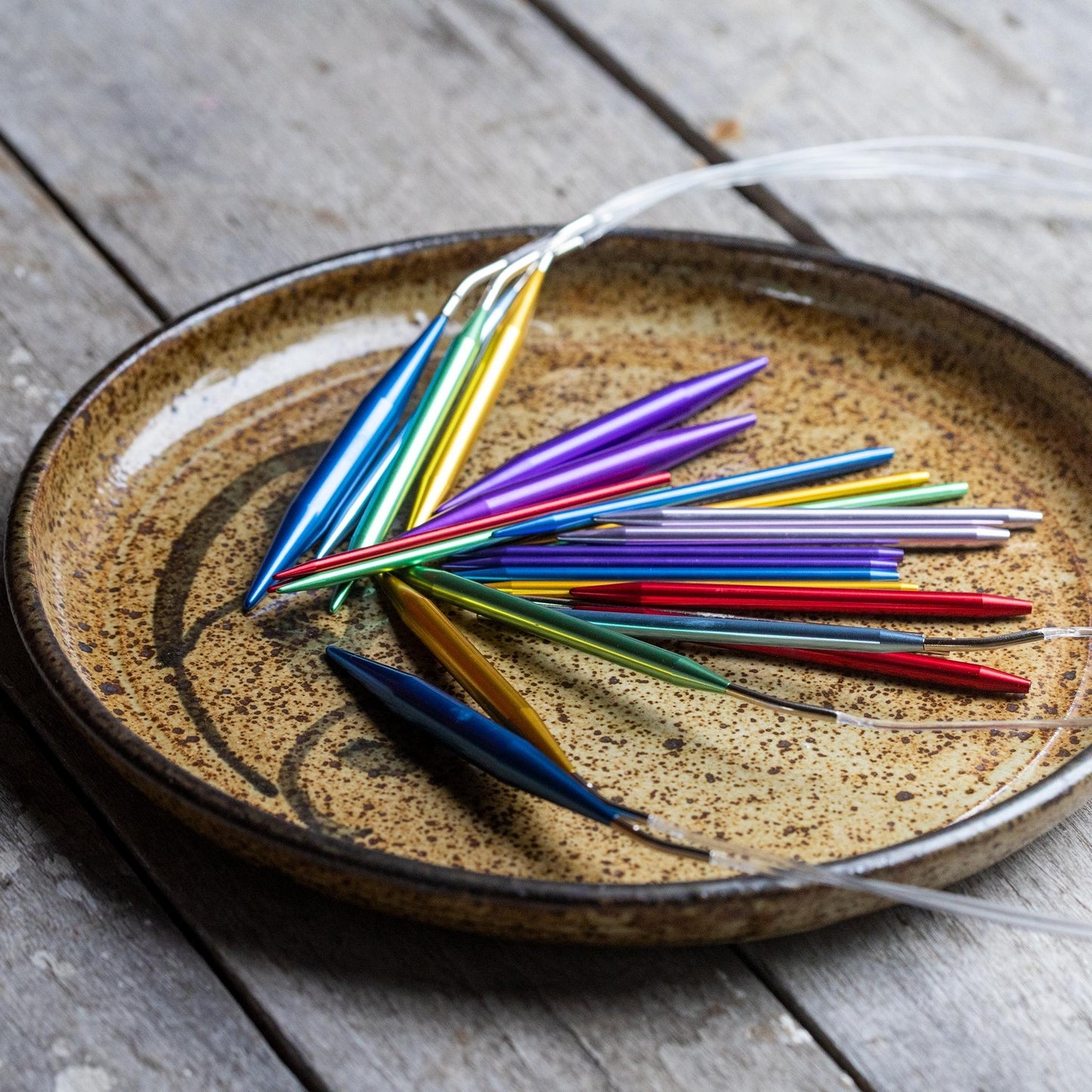 Some Aluminum knitting needles in a bowl.