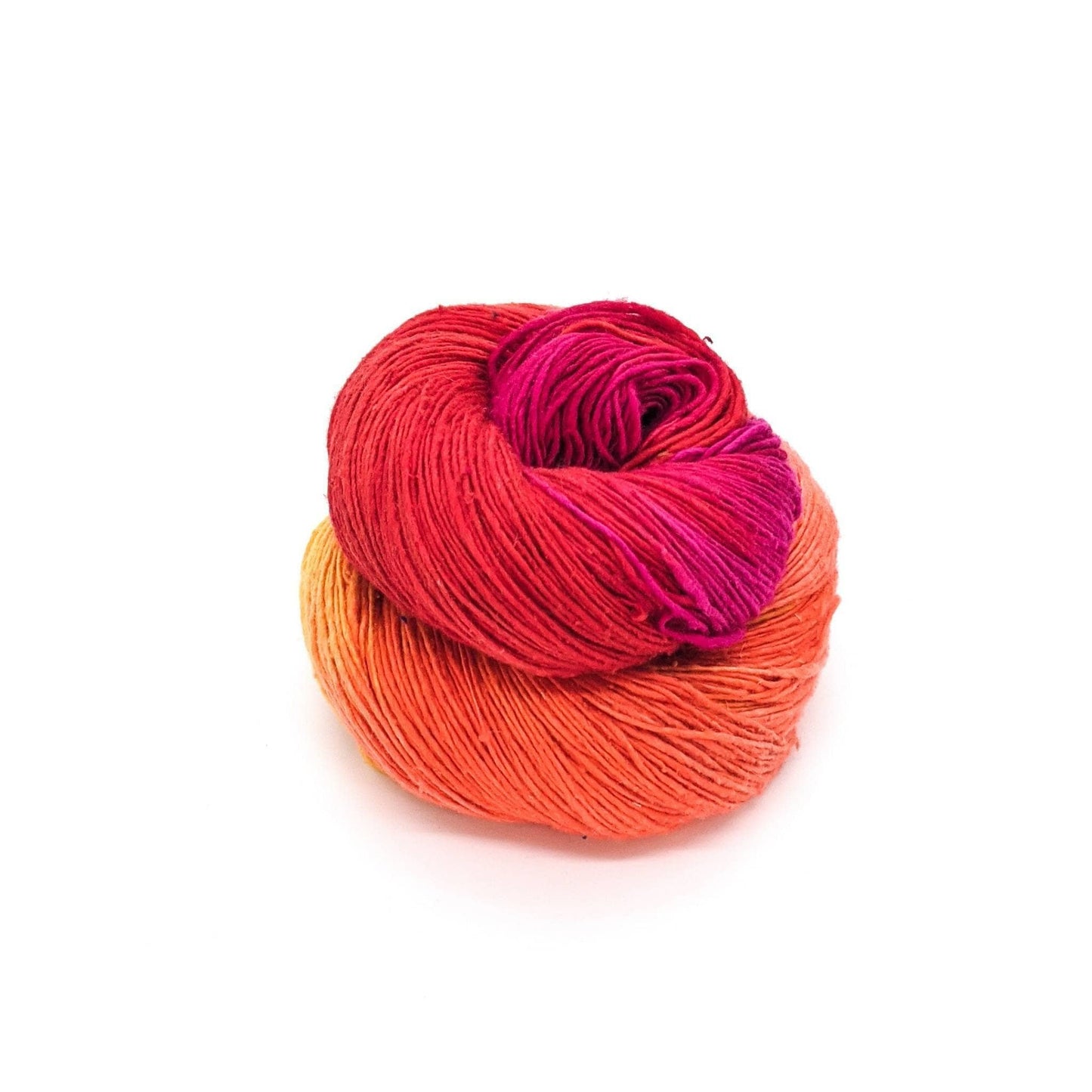 Lace weight silk yarn in color way color surge (orange, yellow and pink) in front of white background.