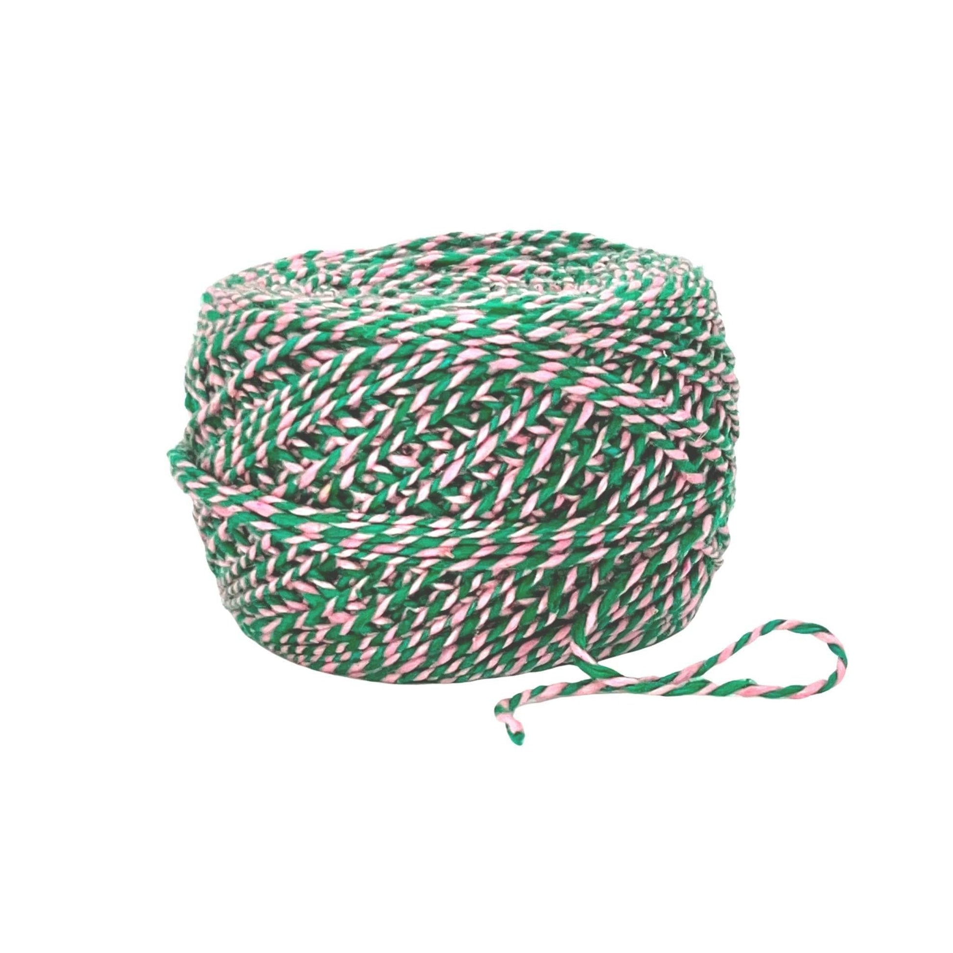 skein of plied marled green and pink reclaimed silk yarn in front of a white background.