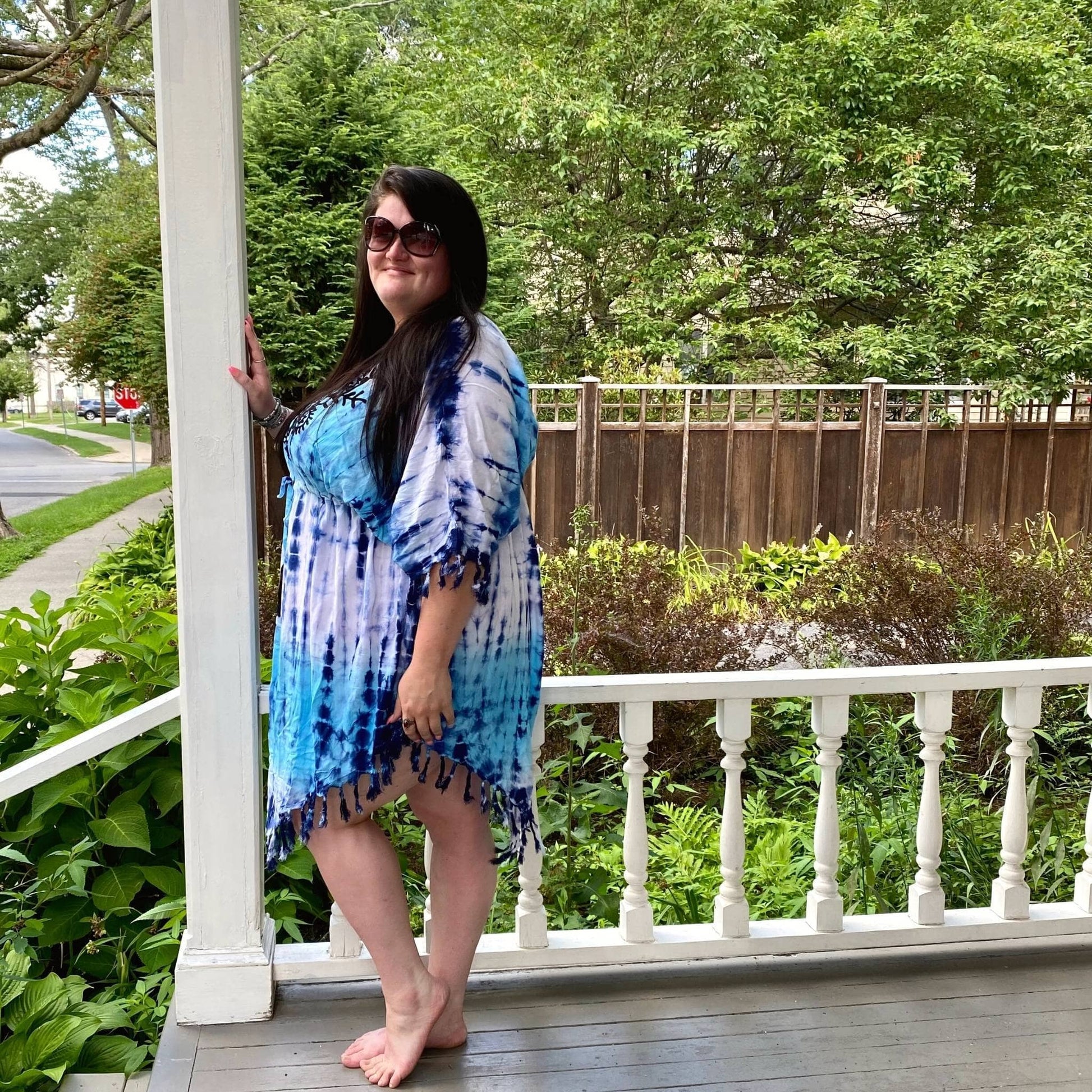 Model is standing on a porch wearing the Dusky Tie Dye Cover Up