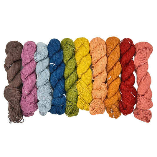 Sport weight herbal dyed mini skein multipack arranged in a line in front of a white background.