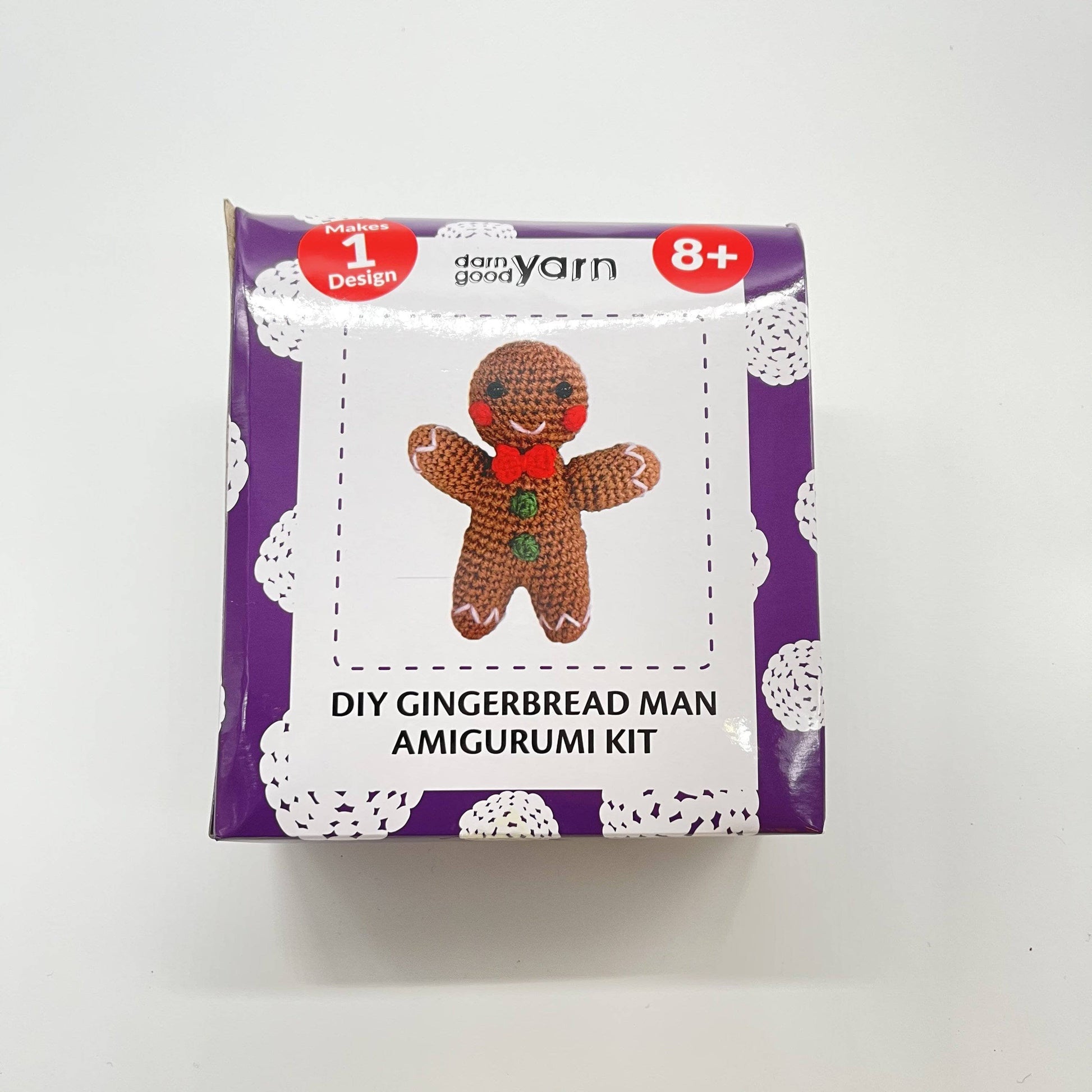 DIY gingerbread amigurumi knit or crochet kit in packaging in front of a white background.