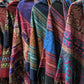 6 one of a kind nanda hooden ponchos hanging together to show variety in fabrics.