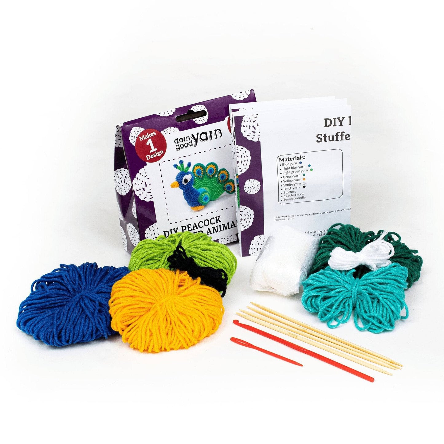 purple and white cardboard box with all contents visible in front of a white background. Yarn, needle, hook, knitting needles, stuffing, and instruction booklet.