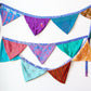 Handmade Recycled Sari Silk Bunting Banner hanging in a white wall