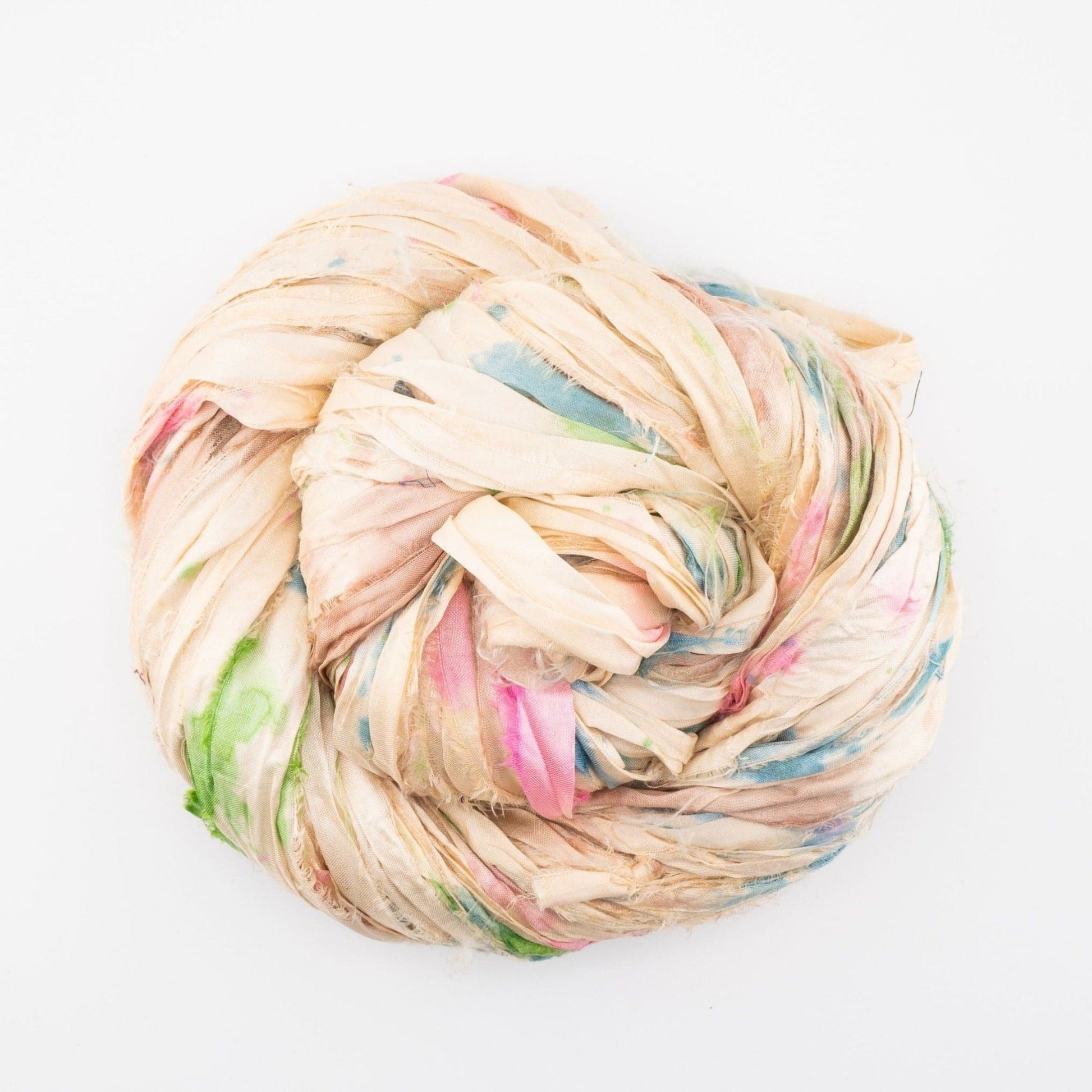 A tightly coiled bundle of off-white fabric with scattered patterns.