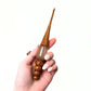 Two wooden and resin crochet hooks.