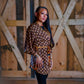 Model is standing in front of a wooden wall wearing a brown short charlotte chic short robe.