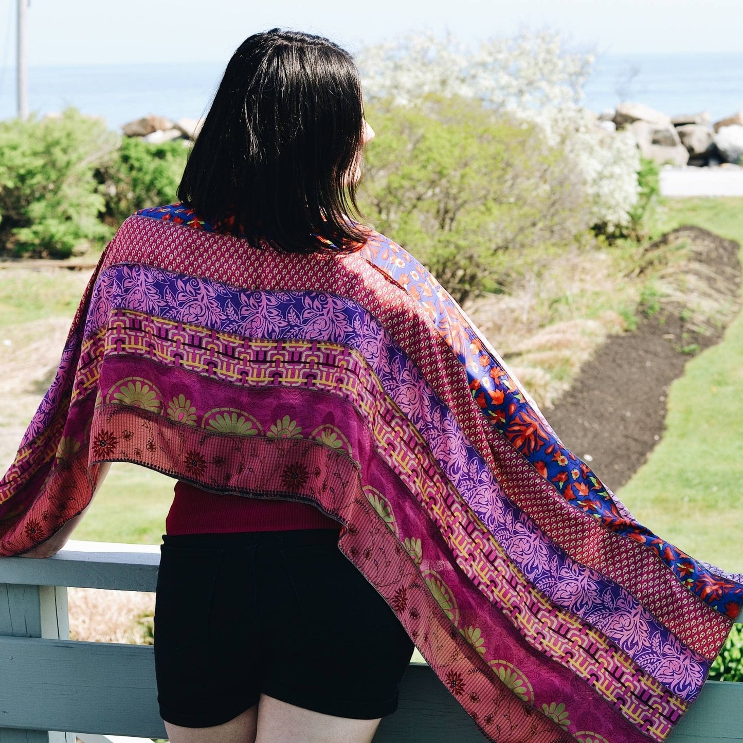 pink Medley scarf sitting on the back of models shoulders while they look into the distance. 