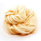 White thick and thin wool yarn ball on a white background