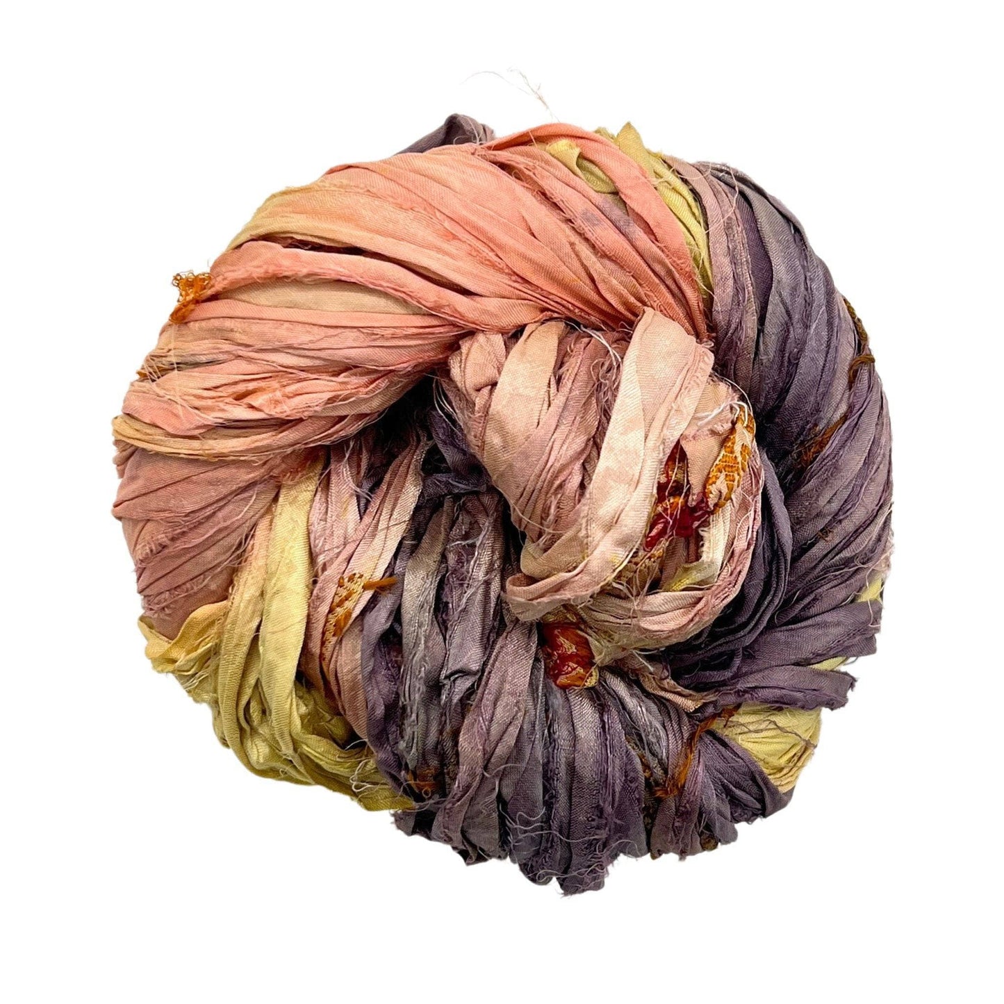A tightly wound ball of fabric strips in pink, purple, and yellow shades.