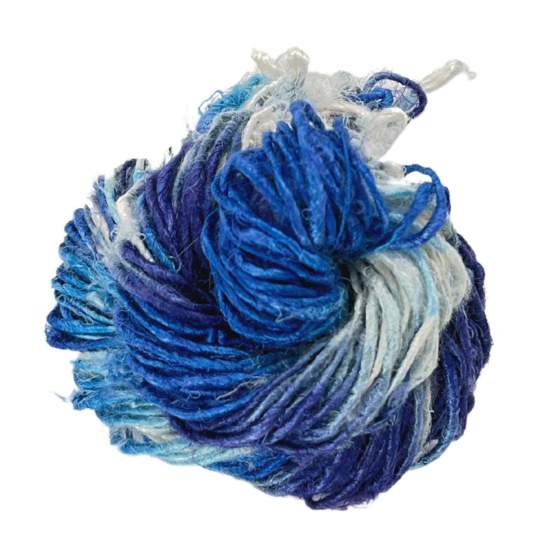 Top view of skein of Ikat Indigo banana fiber yarn curled into a birds nest shape in front of a white background.