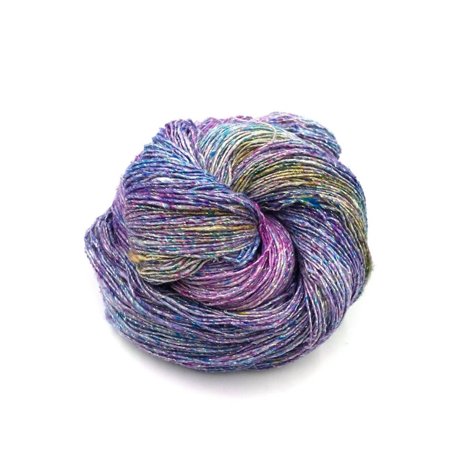 Lace weight silk yarn in color way Sparkle- Tidal Pool ( blue, purple and sparkle) in front of white background.