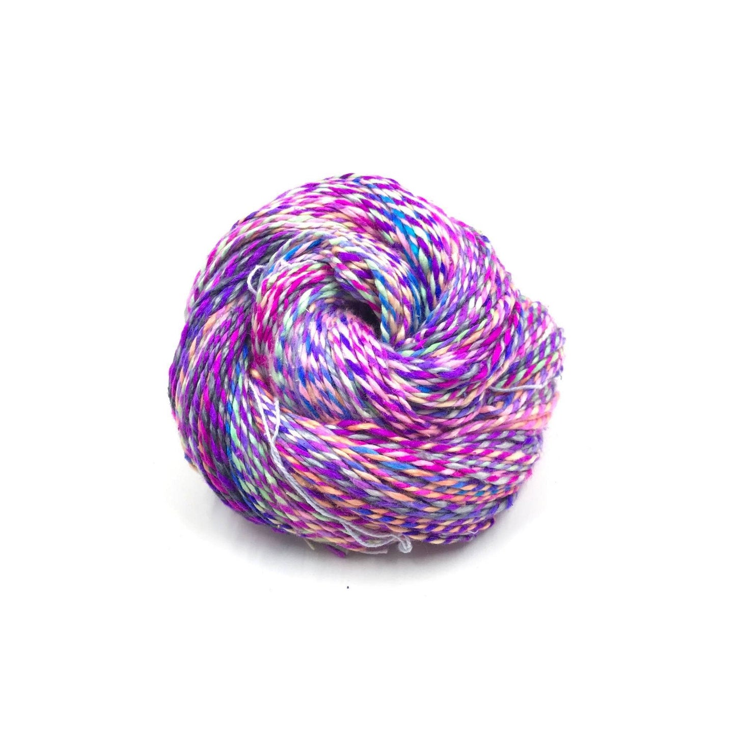 ball of sport weight silk in color way fancy flamingo. Pink, Purple , and light blue marled yarn in front of a white background