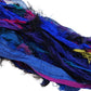 An up closer view of the Indigo sari silk ribbon on a white background. The Indigo includes rich plum purples and blues to blacks and pinks with hints of gold.