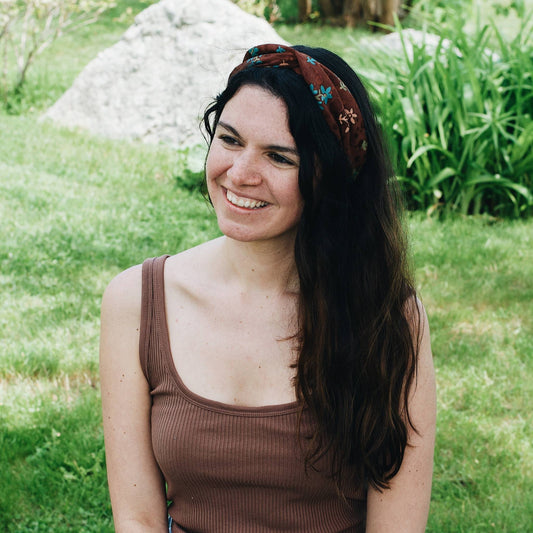 Model is wearing a brown kameela knot headband while standing outside.