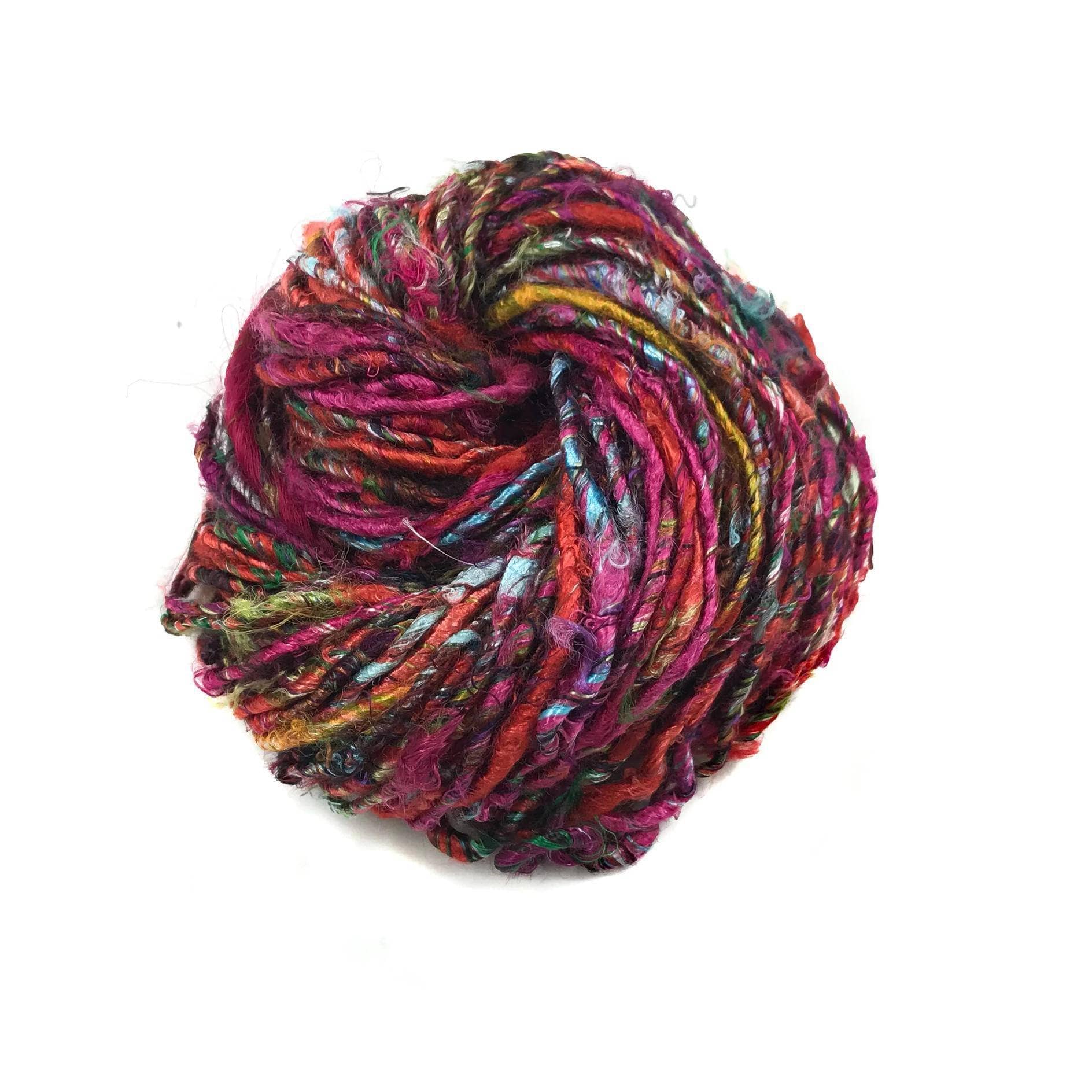 Top view of skein of Kaleidoscope banana fiber yarn curled into a birds nest shape in front of a white background.