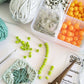 open bead case with beads, wires, and earring hooks showing in front of a white background. Yarn with beads strung onto it, a crochet hook, scissors, and instructions are scattered around.