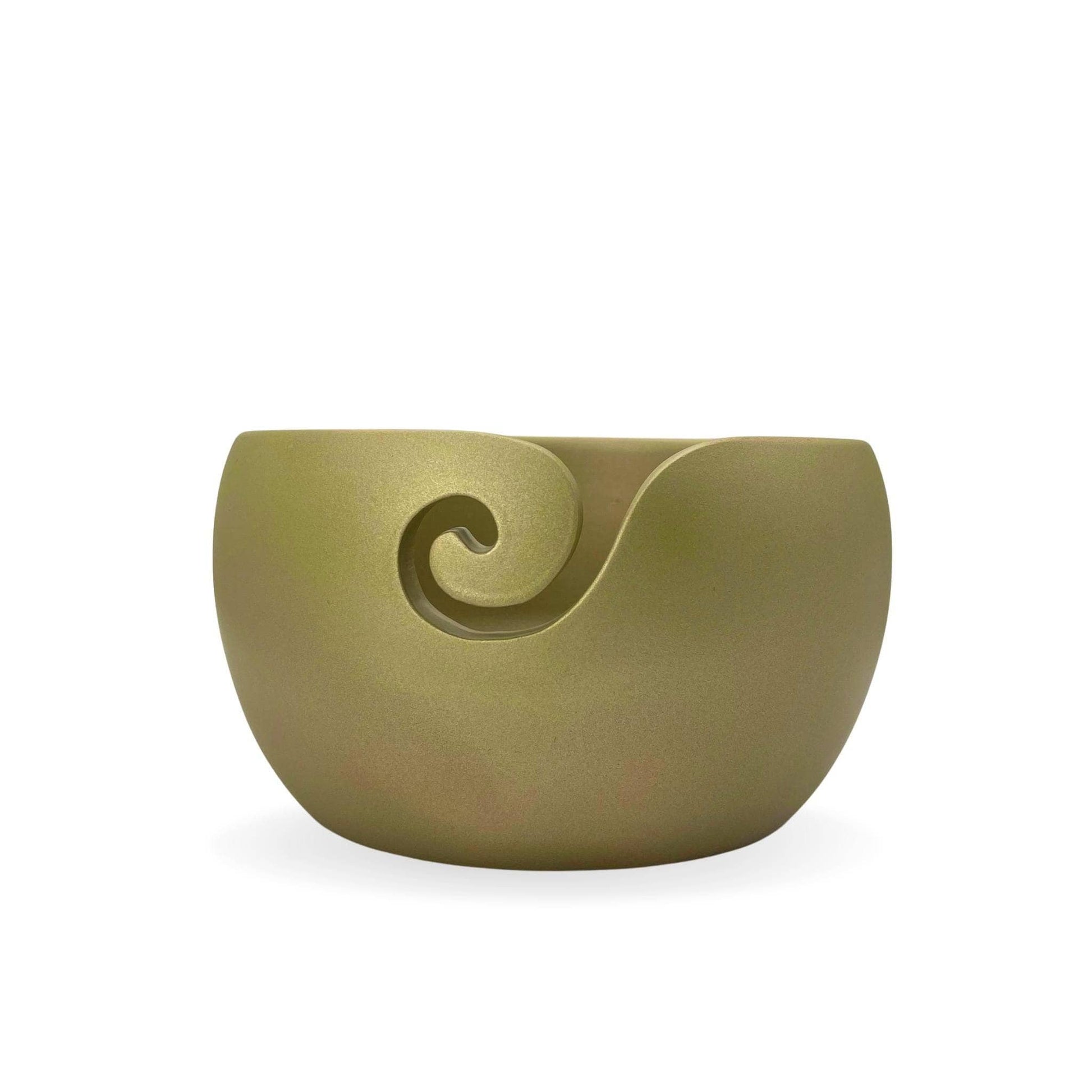 Gold wooden yarn bowl in front of a white background.
