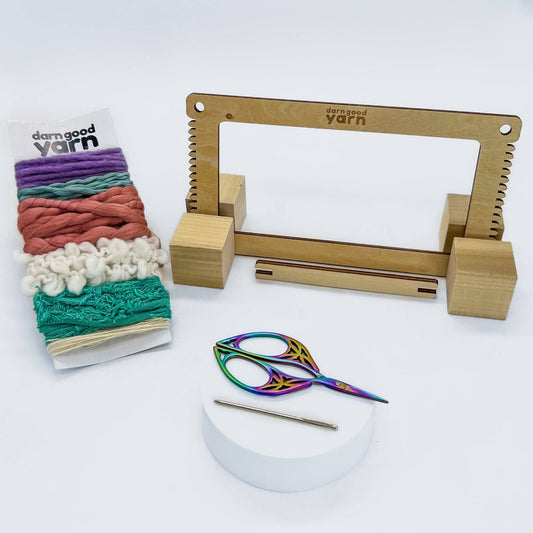 Mini loom kit for weaving with all items showing in front of a white background.