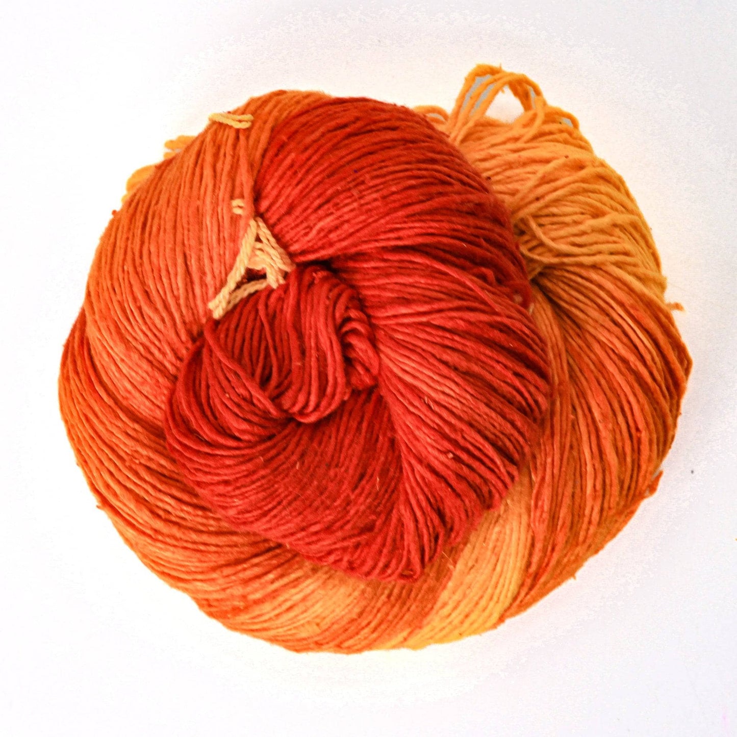 variegated ombre lace weight orange in front of a white background.