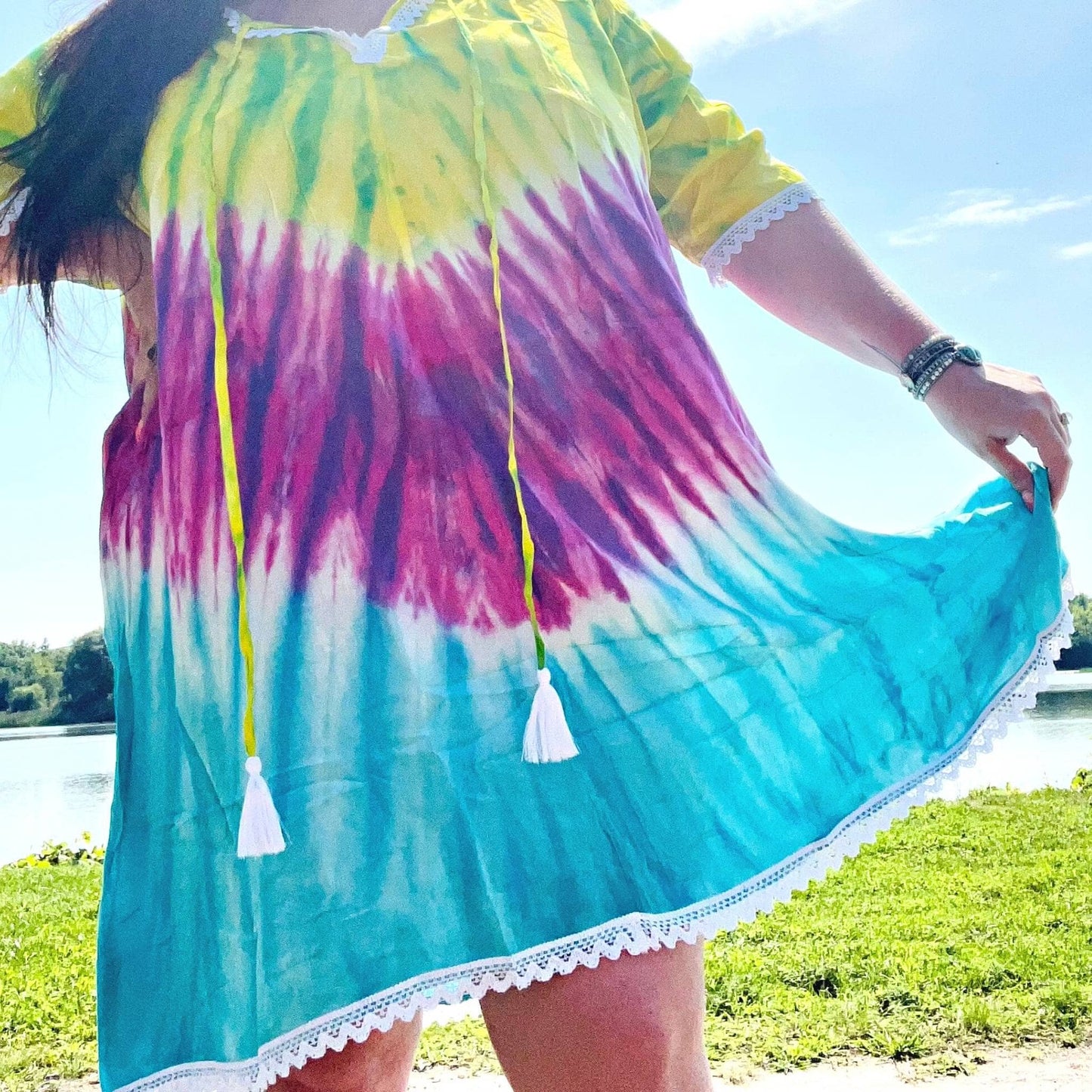 Close-up of brilliant tie-dye coverup. A lake is in the background.