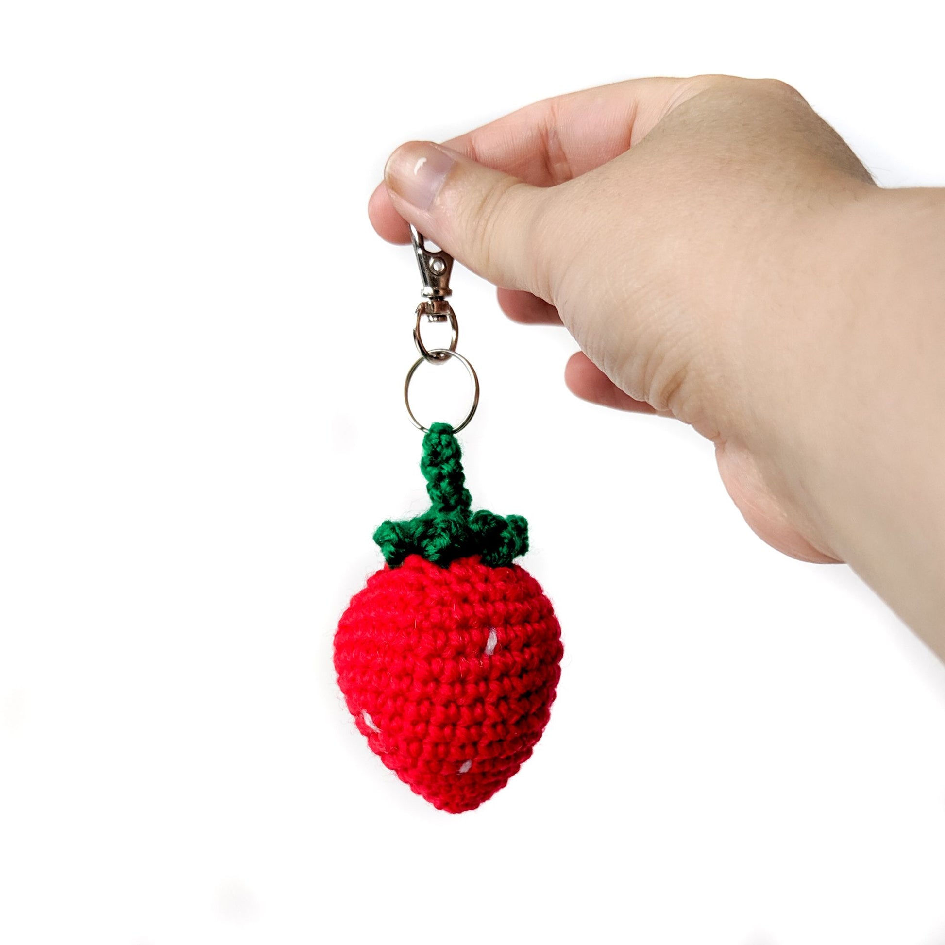 A Keychain Strawberry Amigurumi made with red and green acrylic yarns