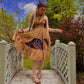 Model walking on a bridge wearing a brown sedona skirt as a dress.