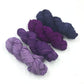 Chiffon Ribbon yarn is the colorway Mumbai on a white background. These colors are light lavender to plum purple.