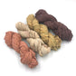 Chiffon Ribbon yarn is the colorway Neutrals on a white background. These colors are warm browns, tans and creams.