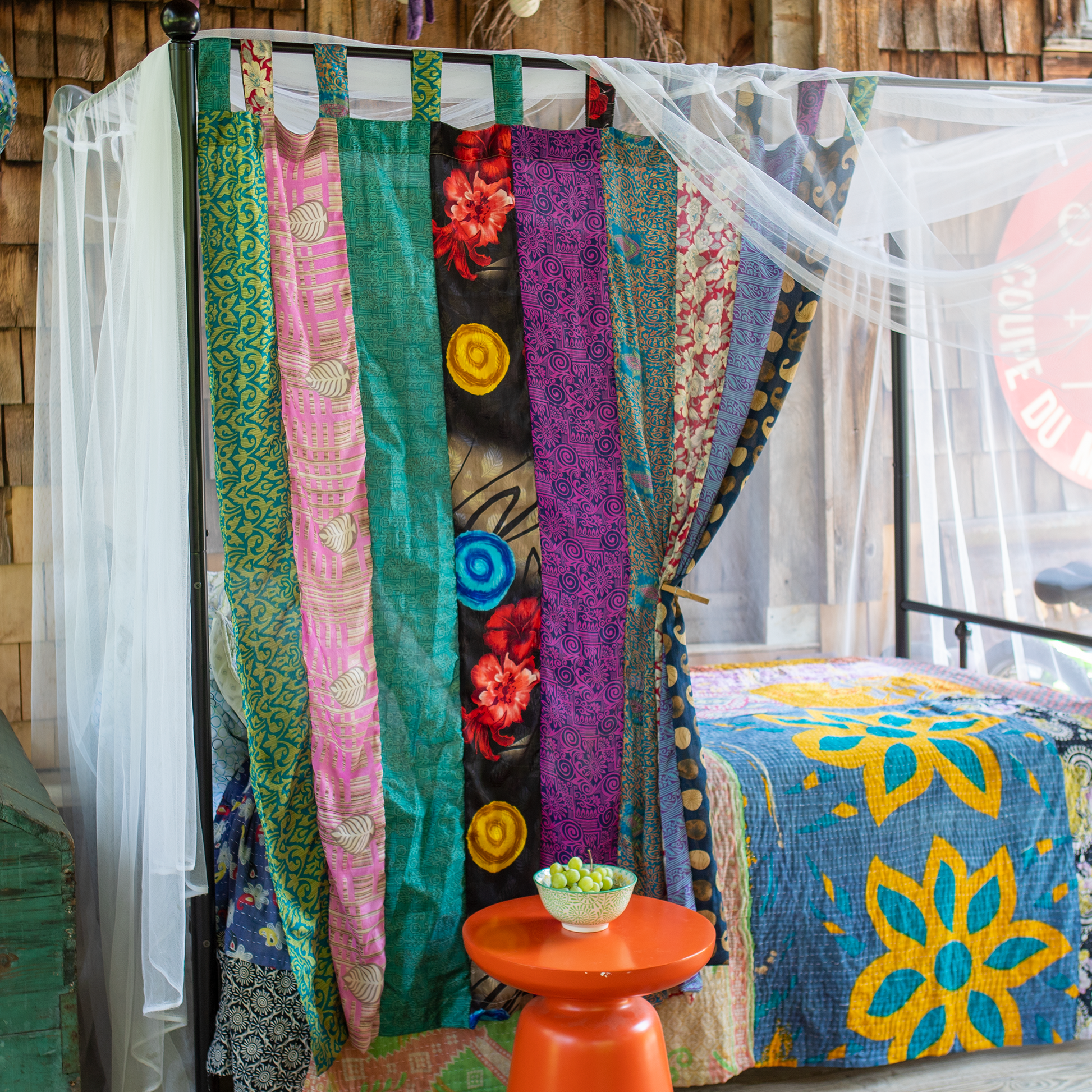 Canopy bed with a one of a kind recycled sari drape hung on it