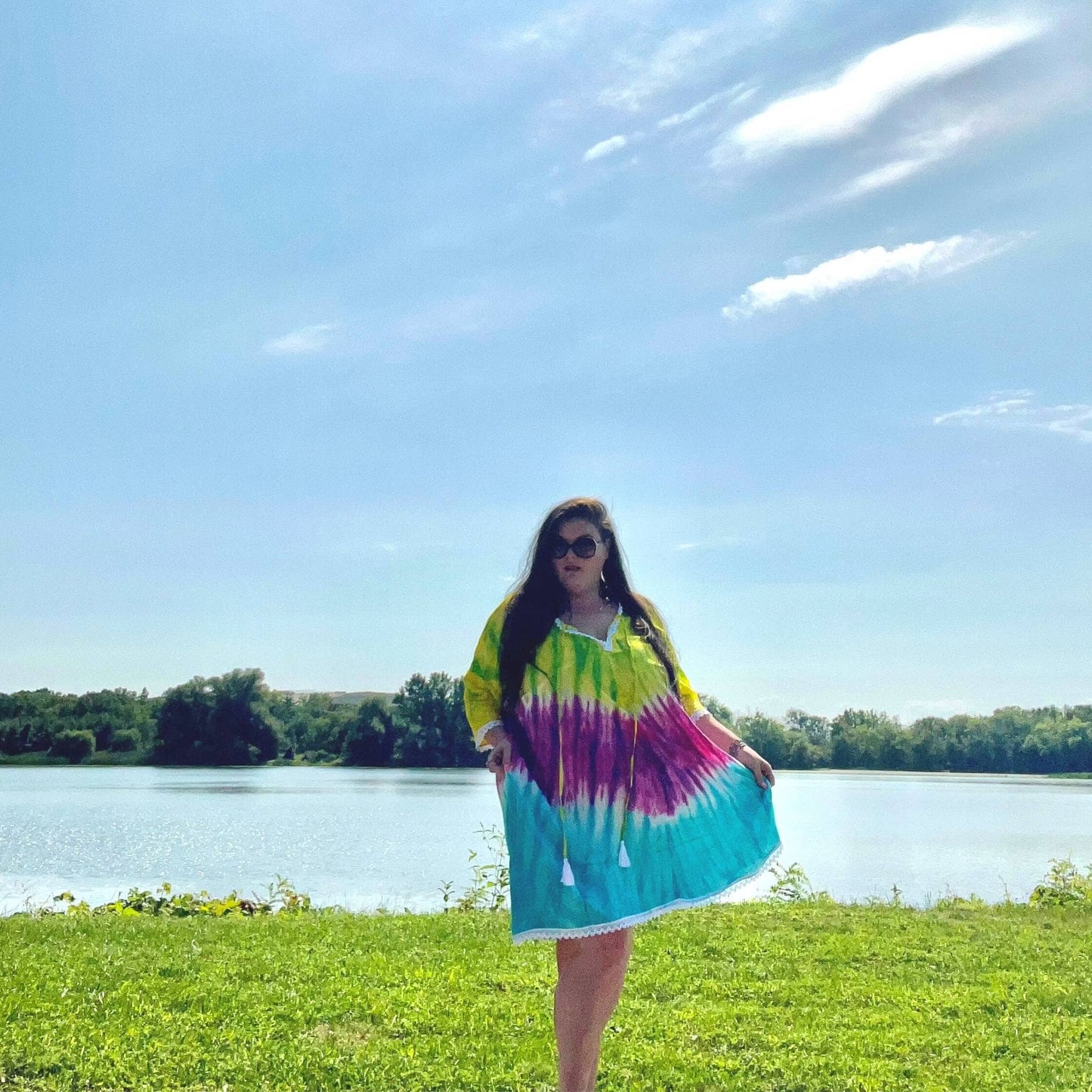 Model is standing in front of water wearing a brilliant tie-dye coverup in our goddess size.