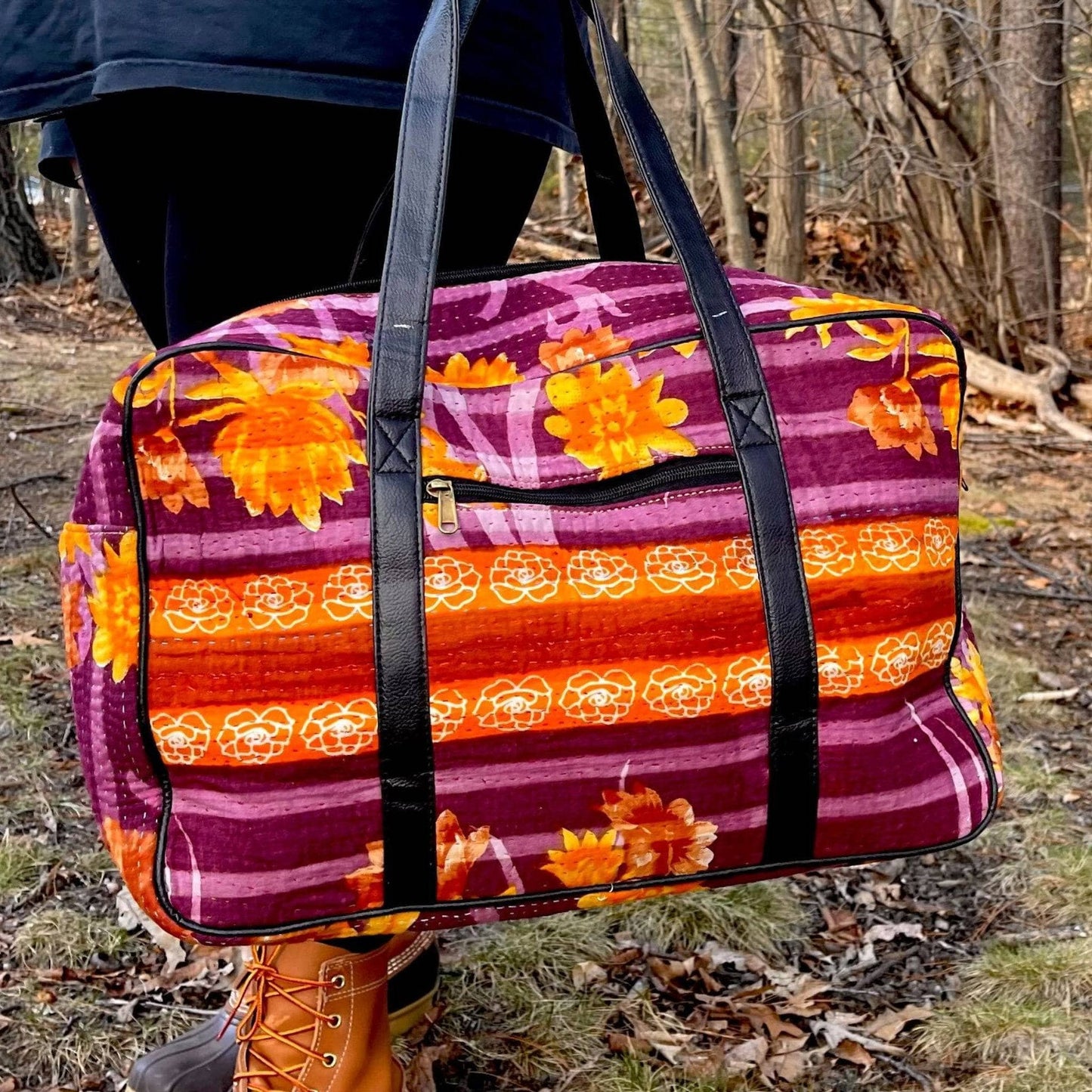 A Vibrant Purple and Orange Kantha Stitched Duffle Bag with Flowers on it.