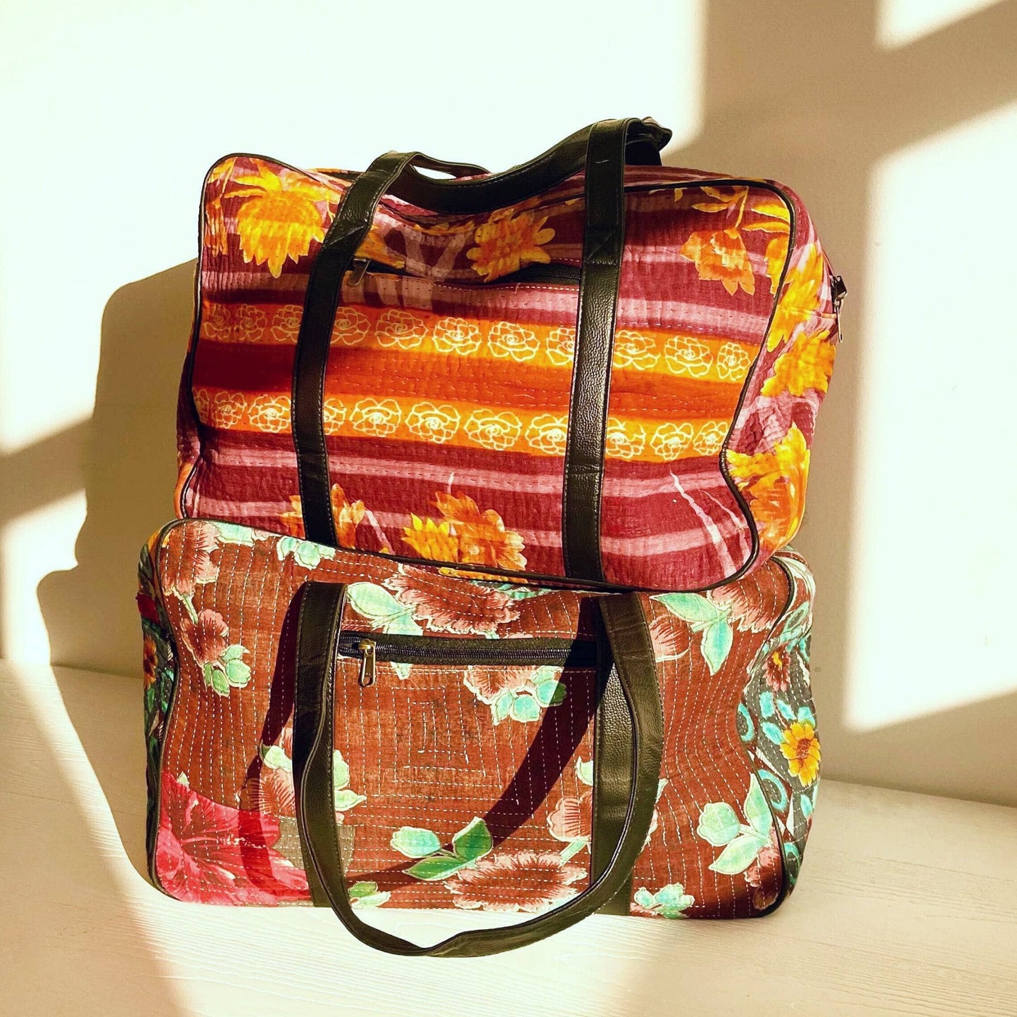 Two Kantha Duffle Bags Stacked on top of each other in the sunlight