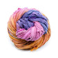 A variegated skein of yellow, purple, and pink sari silk ribbon on a white background