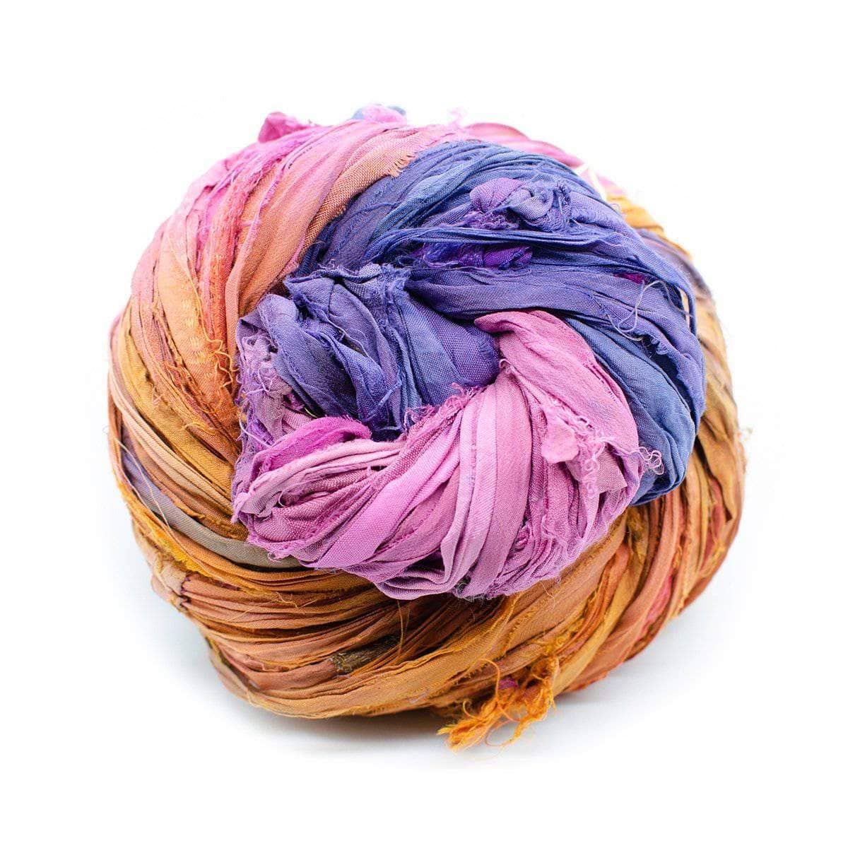 A variegated skein of yellow, purple, and pink sari silk ribbon on a white background