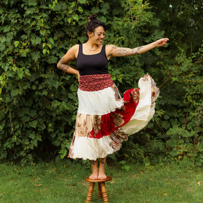 Model is standing on a small stool wearing a red and white sedona skirt.